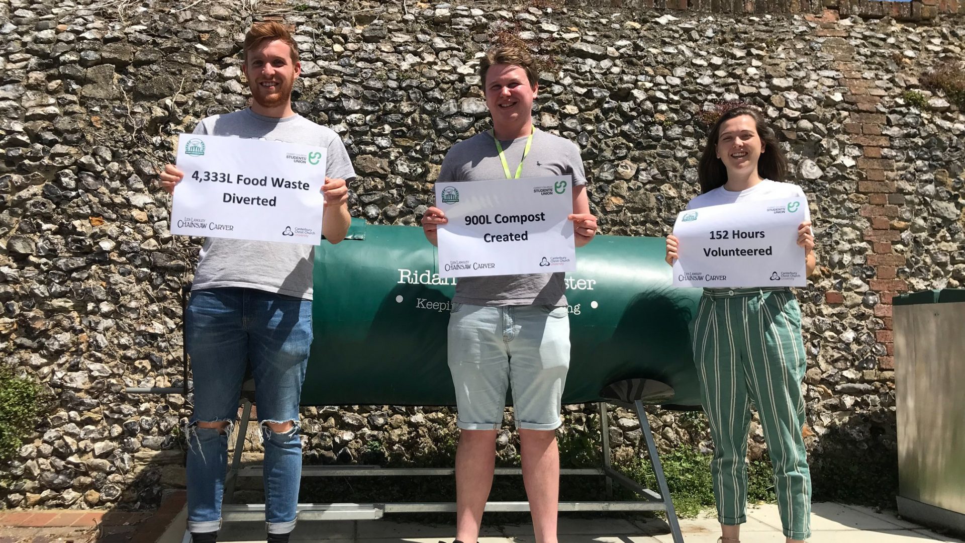 People holding signs with the benefits of composting food waste