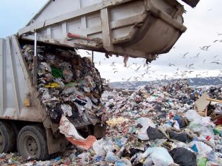 Bin wagon empyting waste into landfill